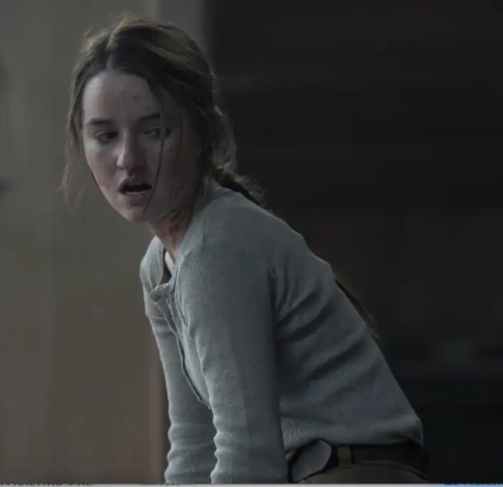 The girl in the grey sweater is looking at something