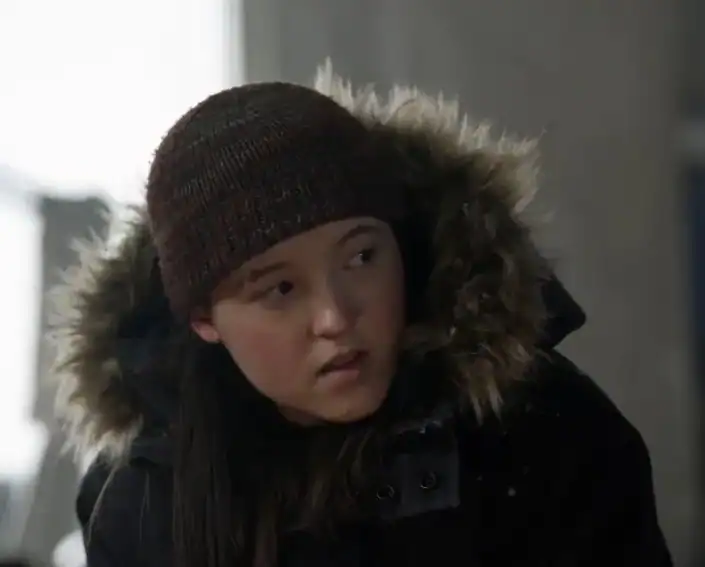 A young woman wearing a hat and coat