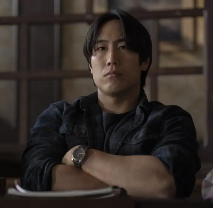 A man with a watch sitting at a table